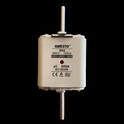An Omesto NH2 electrical fuse, model 355A, 350V~ 120kA, 650VDC 250VAC, lying on a wooden surface. The fuse has a white ceramic body with silver metal terminal posts extending from the top and bottom, and black printed specifications on the front face.